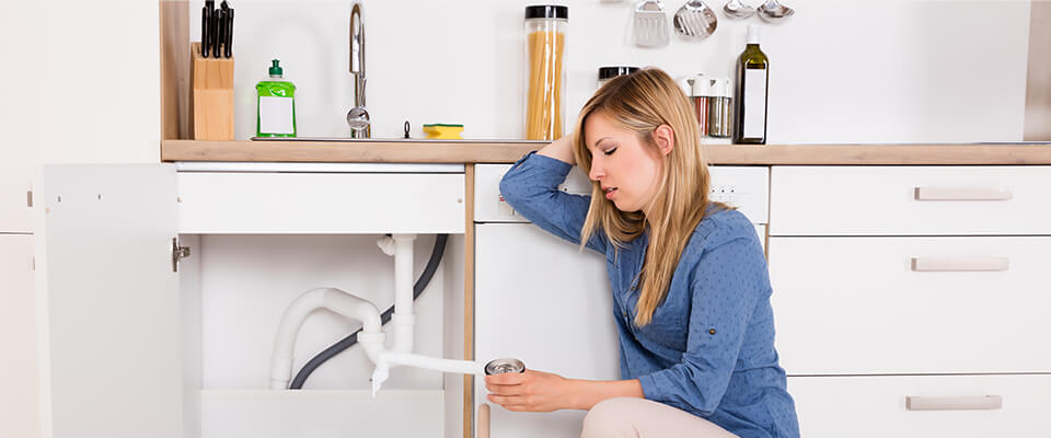 Frustrated woman having a problem with the kitchen sink