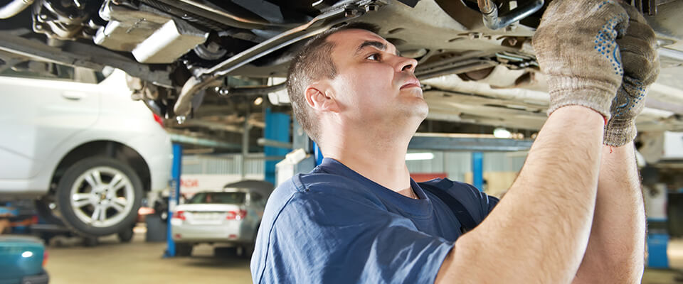 Mechanic working on the underside of a car
