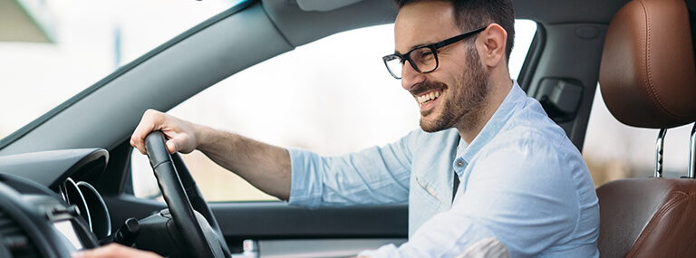 Man with glass smiling in car